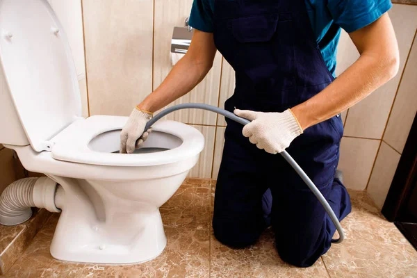 EZO engineer unblocking a household drain in a bathroom