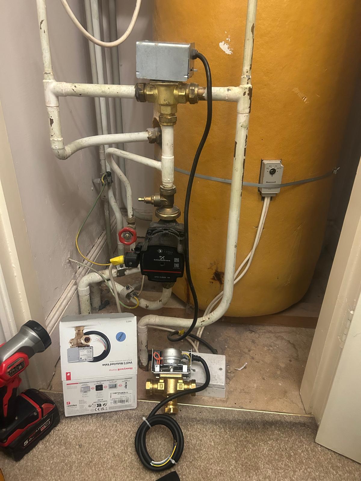 Hot water cylinder cupboard with pipework and a motorised valve